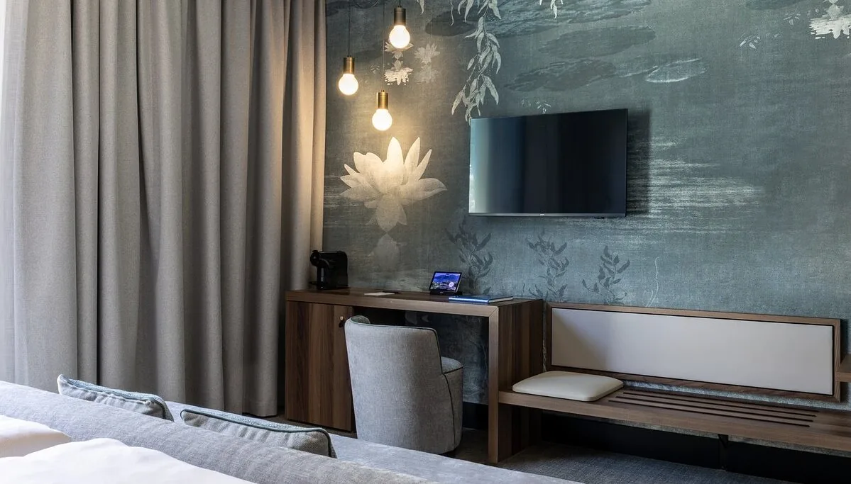 A bedroom with a mural behind the headboard and pendant lights