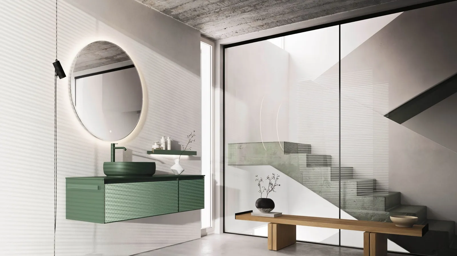 Colección Absolute: mueble verde con lavabo sobre encimera y espejo redondo.