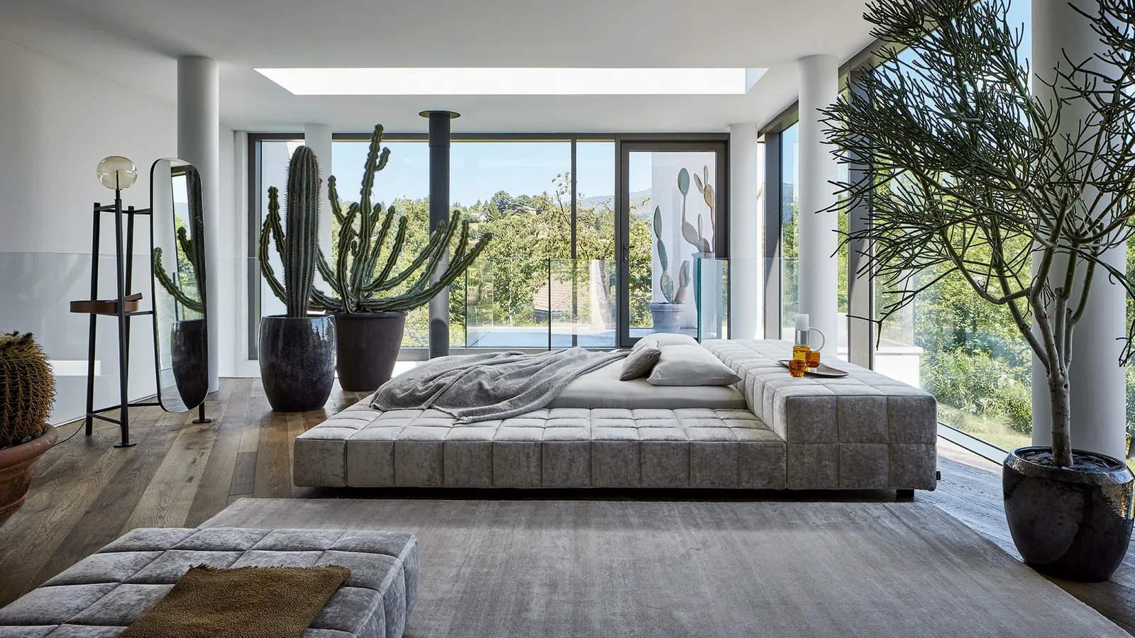 Cama de matrimonio Bonaldo sobre una base baja acolchada.
