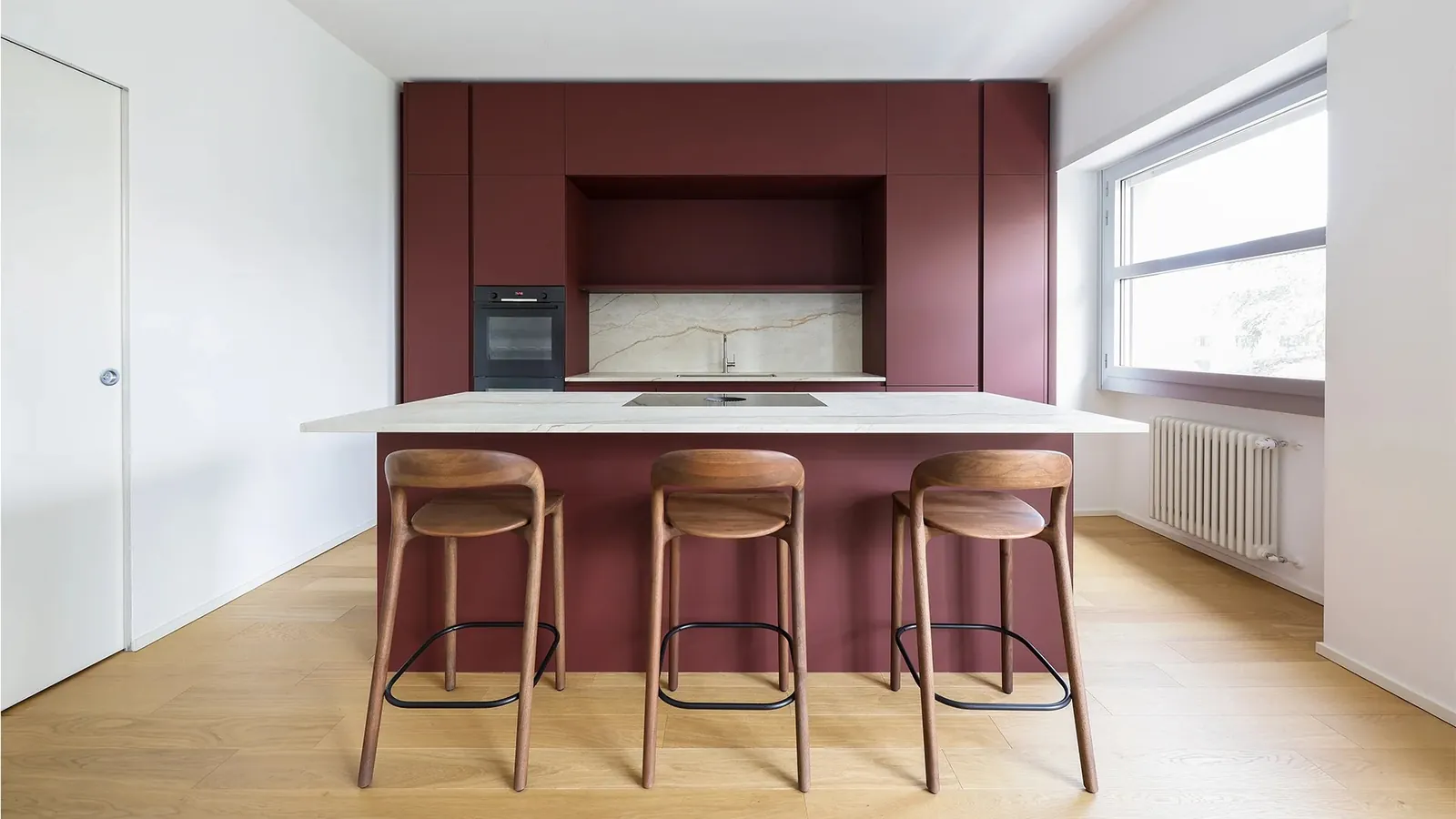 Cocina M2 en acabado Fenix Jaipur con isla y taburetes.