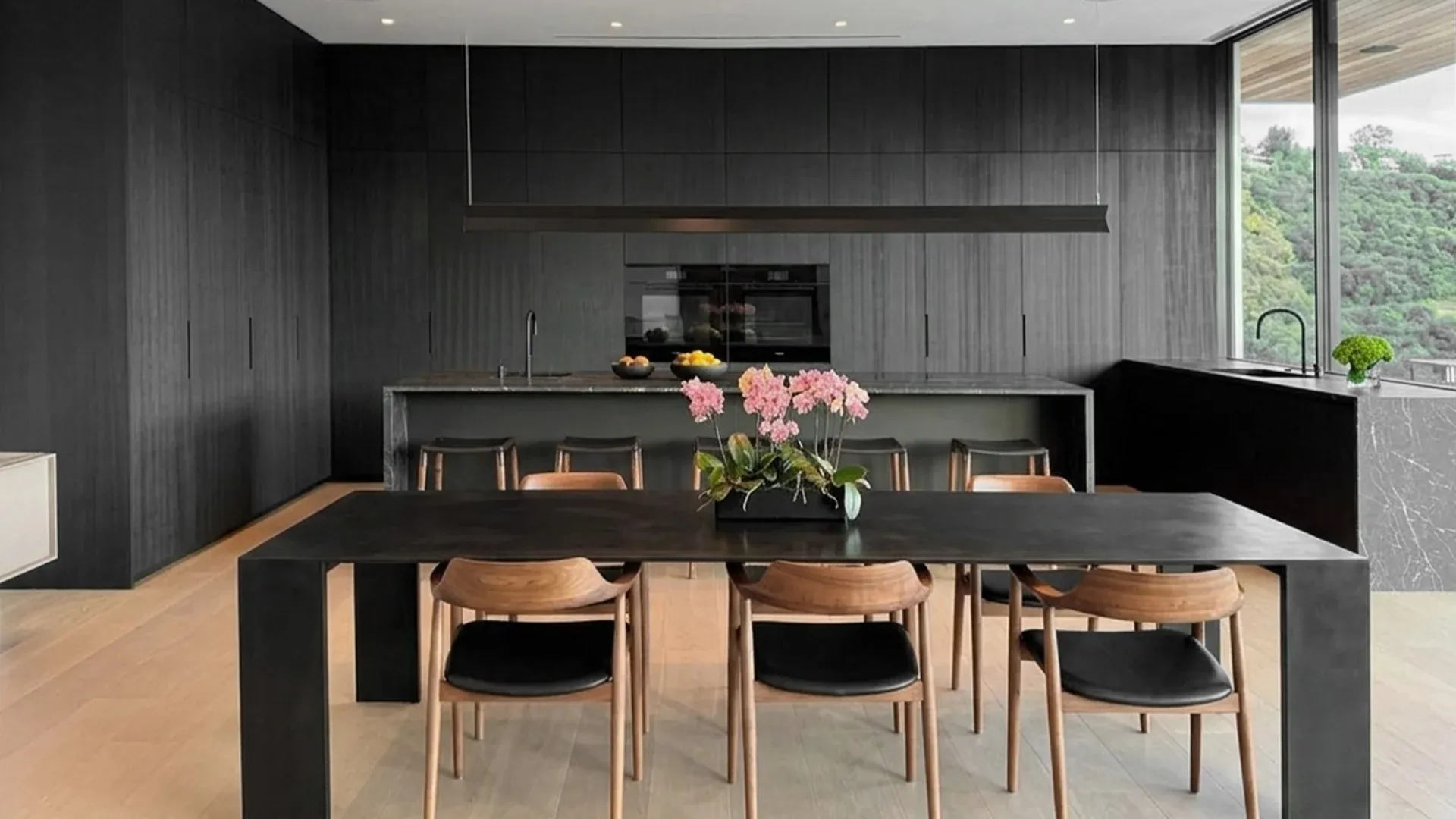 Cocina Minimal Cucine en madera oscura con isla y mesa de comedor