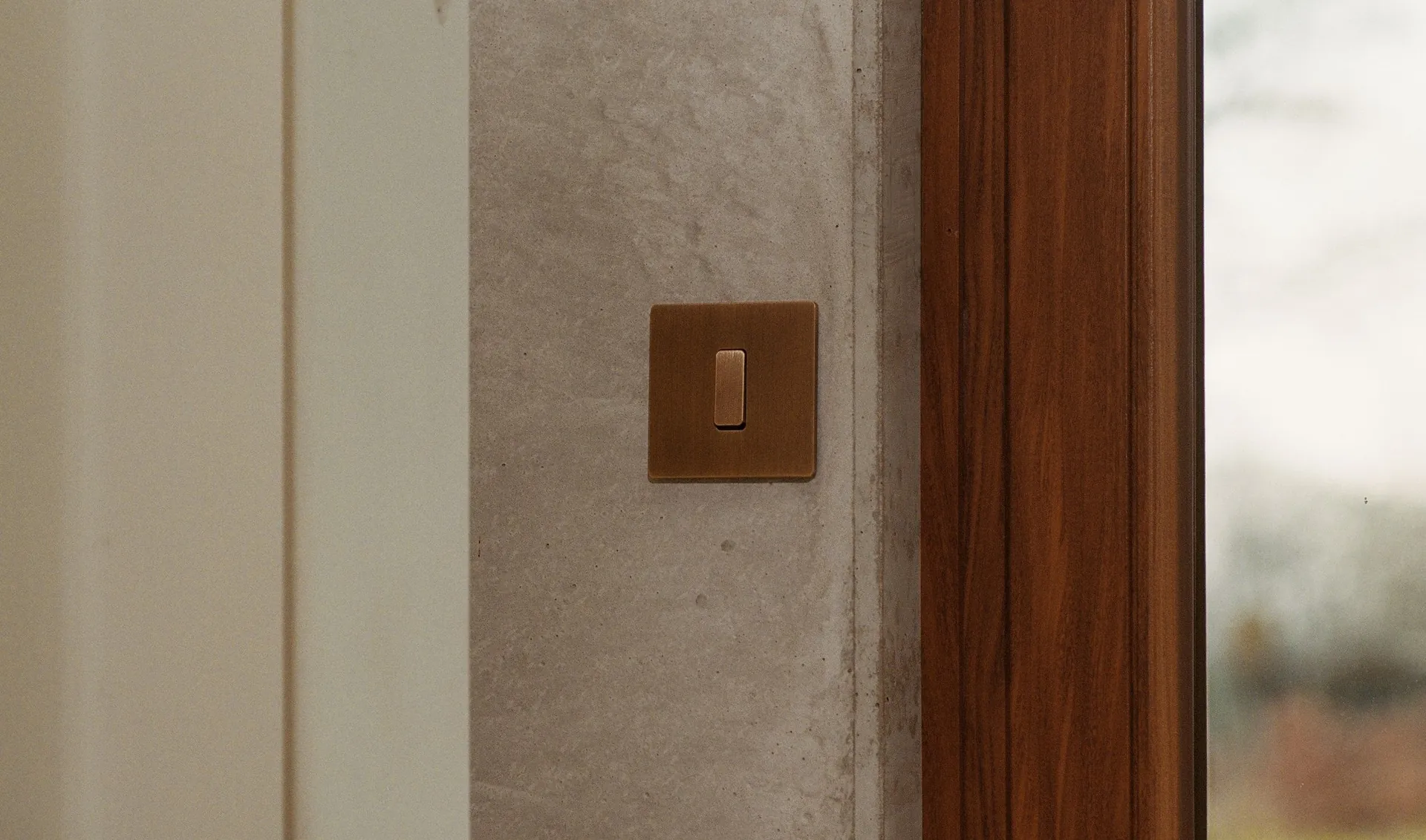 Interruptor Modelec de la colección M en una pared de hormigón junto a una ventana