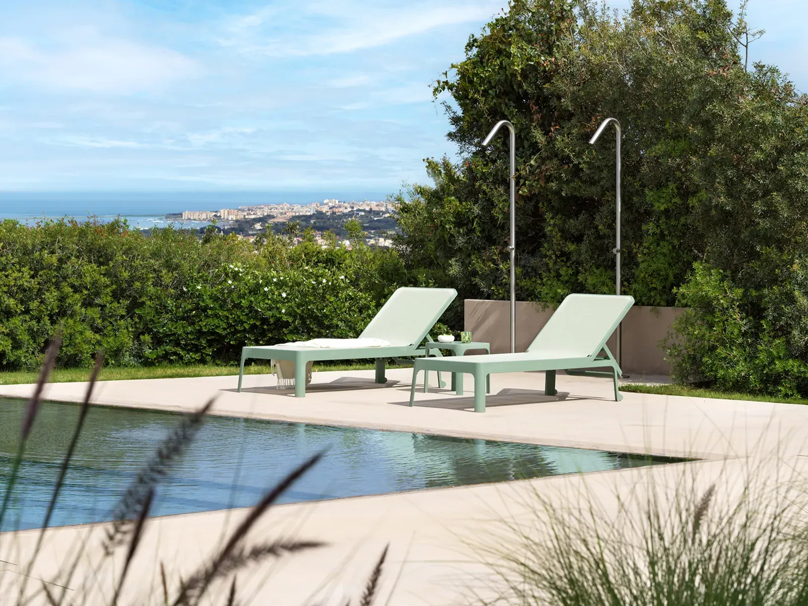 Tumbonas junto a una piscina con vistas al mar