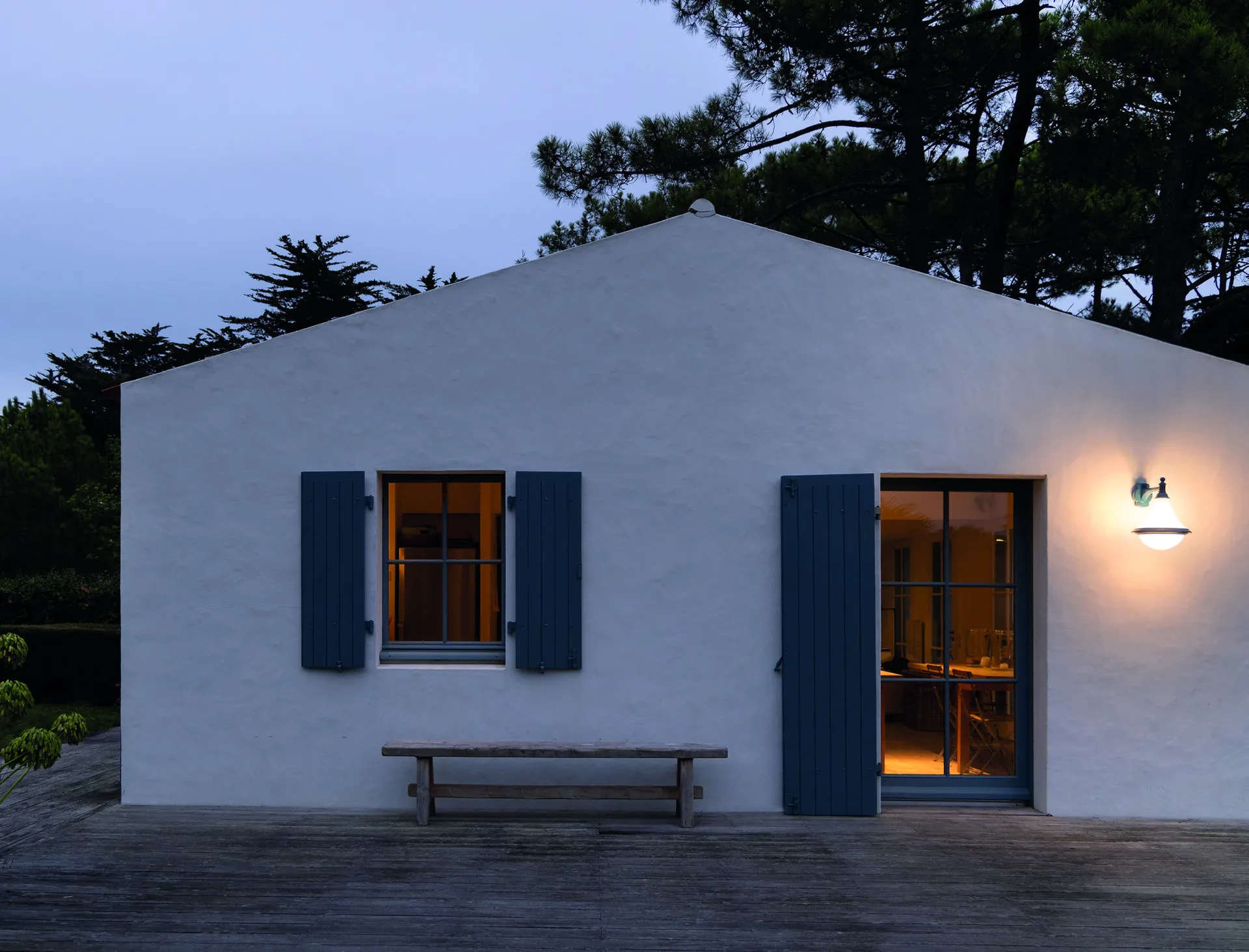 Fachada de una casa al atardecer con apliques Dallas